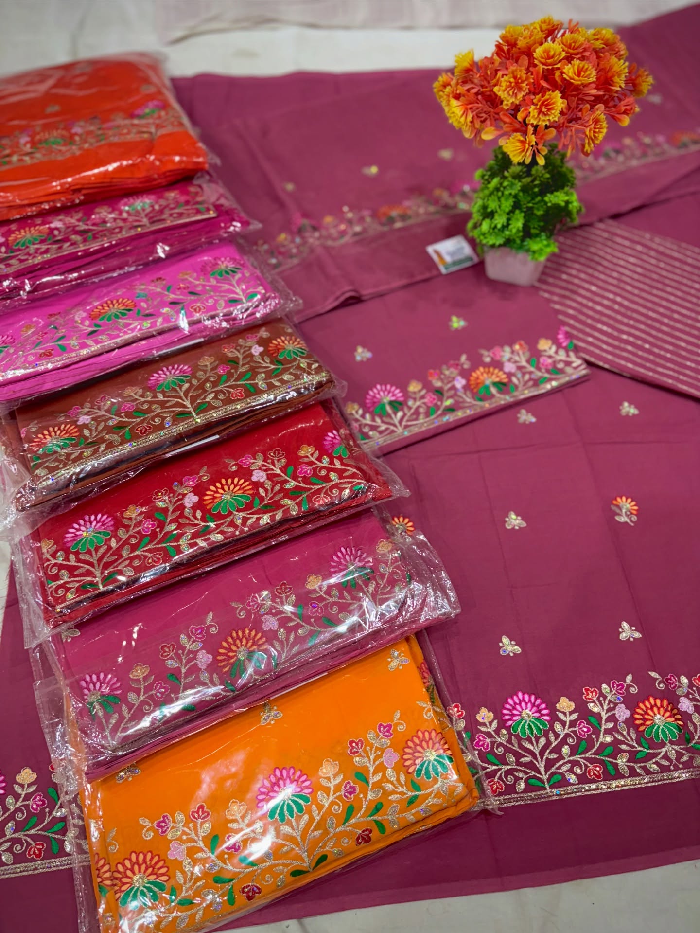 A vibrant collection of multicolor traditional Indian dress materials and saree sets featuring rich fabrics, festive designs, and assorted patterns.